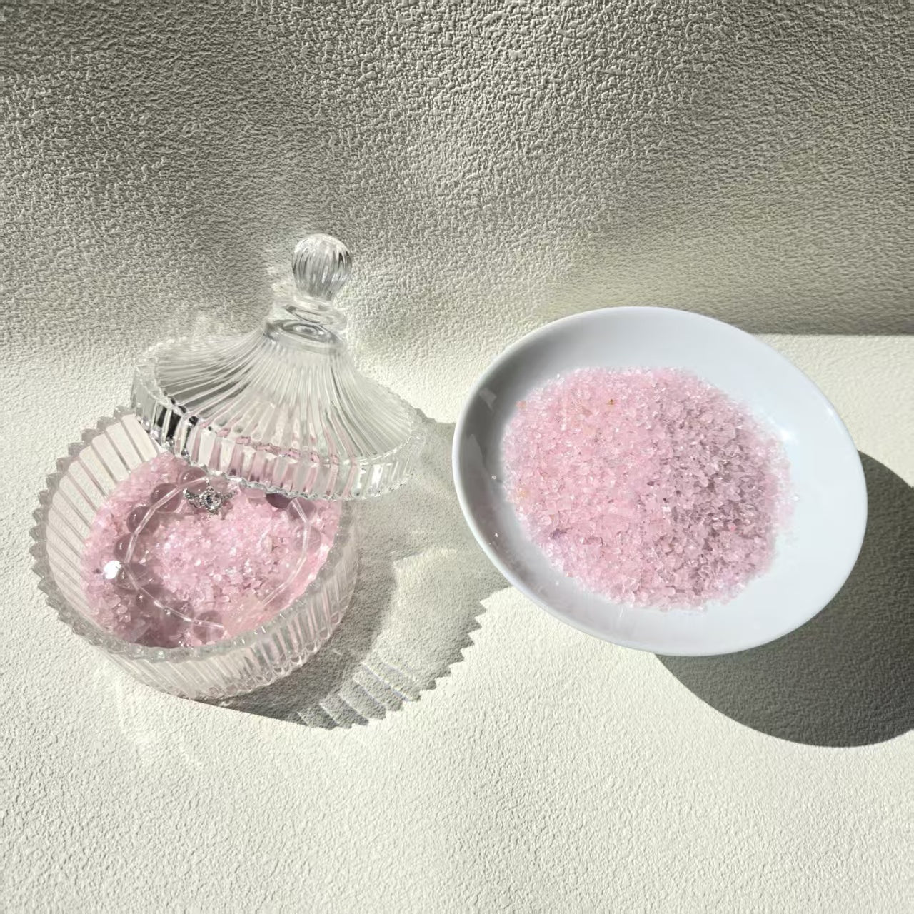 Rose quartz care essentials detail - bracelet resting on rose quartz chips for energy purification